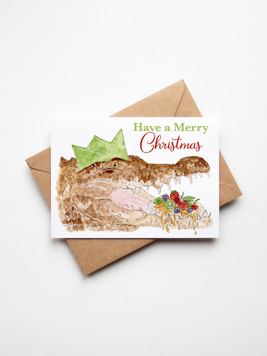 Christmas card with a crocodile wearing a crown and Christmas decorations, on a white background. Top End Christmas cards, Aussie Christmas cards, NT Christmas cards